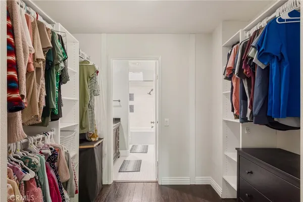 a view of walk in closet with clothes and shoes