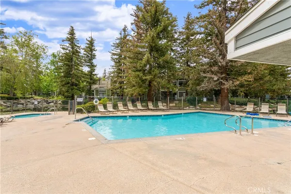 a view of a swimming pool with an outdoor seating and a yard