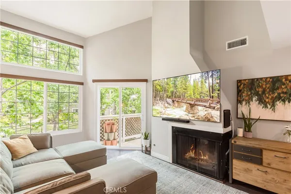a living room with furniture a large window and a fireplace