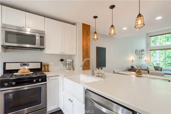 a kitchen with stainless steel appliances a stove a sink and cabinets