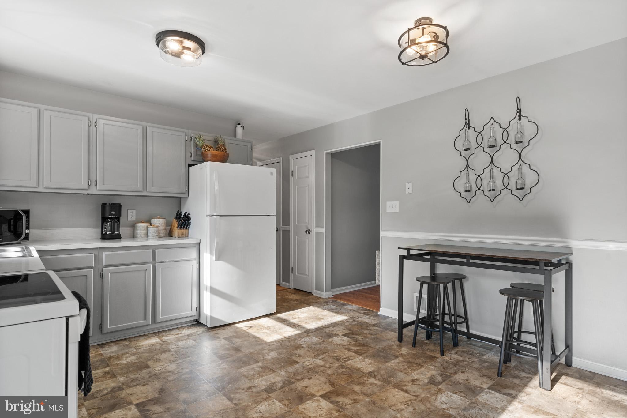 11619 Big Sandy Run Road Lusby, MD 20657 - Photo 6 of 31 a kitchen with a refrigerator and a stove top oven