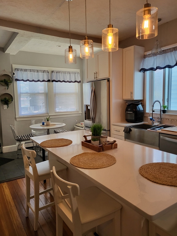 12 Watts Street, Unit 1 Chelsea, MA 02150 - Photo 15 of 29 a kitchen with a sink a stove and chairs