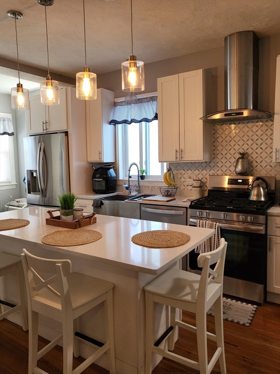 12 Watts Street, Unit 1 Chelsea, MA 02150 - Photo 16 of 29 a kitchen with a dining table chairs sink and stove