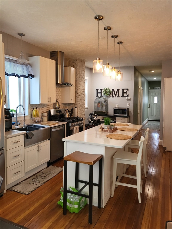 12 Watts Street, Unit 1 Chelsea, MA 02150 - Photo 24 of 29 a kitchen with a table chairs stove and cabinets