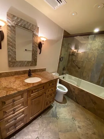 a bathroom with a granite countertop sink toilet and shower