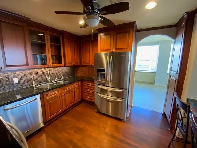 a kitchen with stainless steel appliances granite countertop a refrigerator a sink and dishwasher