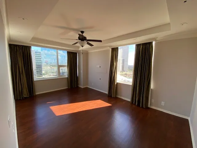 a view of an empty room with window and wooden floor