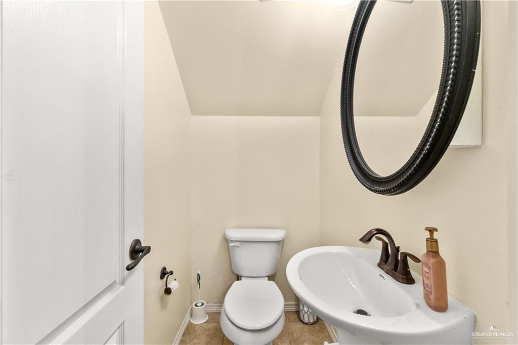 1309 West Fig Avenue, Unit C Pharr, TX 78577 - Photo 13 of 20 a bathroom with a toilet sink and mirror