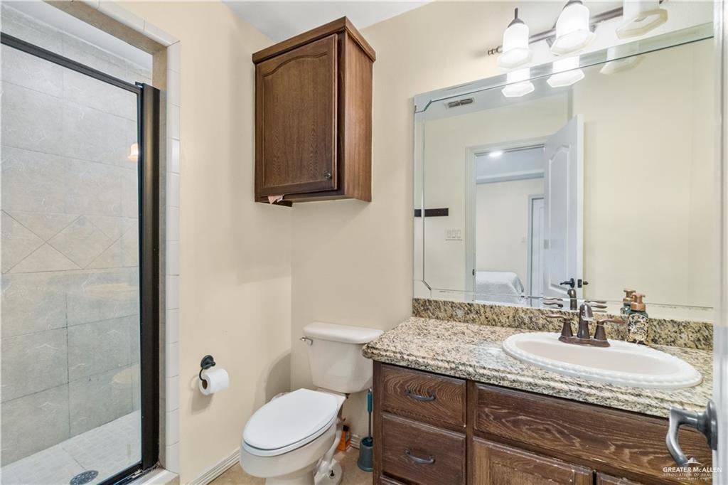 1309 West Fig Avenue, Unit C Pharr, TX 78577 - Photo 15 of 20 a bathroom with a granite countertop toilet sink and mirror