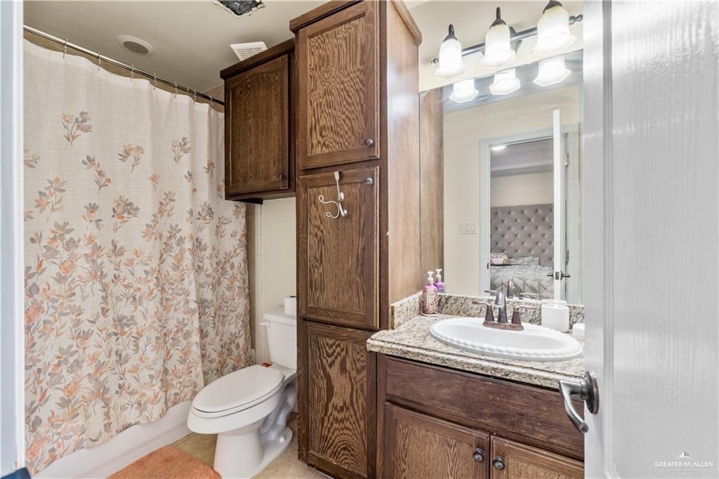 1309 West Fig Avenue, Unit C Pharr, TX 78577 - Photo 17 of 20 a bathroom with a granite countertop sink toilet and shower