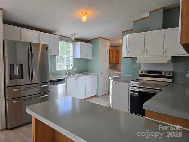 a kitchen with a appliances a sink and cabinets