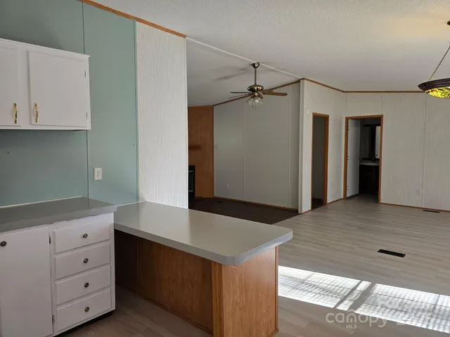 a kitchen with a wooden floor and cabinets