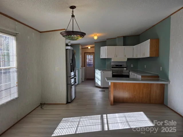 a kitchen with stainless steel appliances granite countertop a stove a refrigerator a sink dishwasher and a microwave oven on the granite countertops