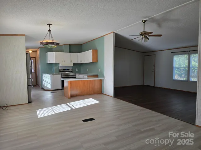 a view of a kitchen with a stove wooden floor and a chandelier