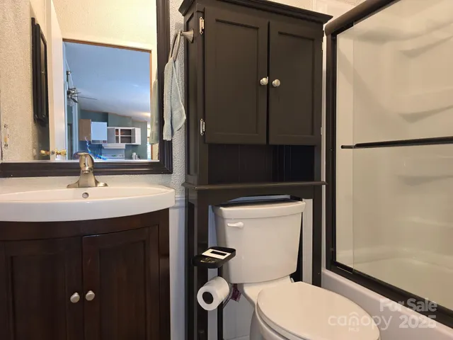 a bathroom with a toilet a sink and mirror