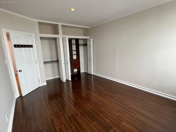 an empty room with wooden floor and closet
