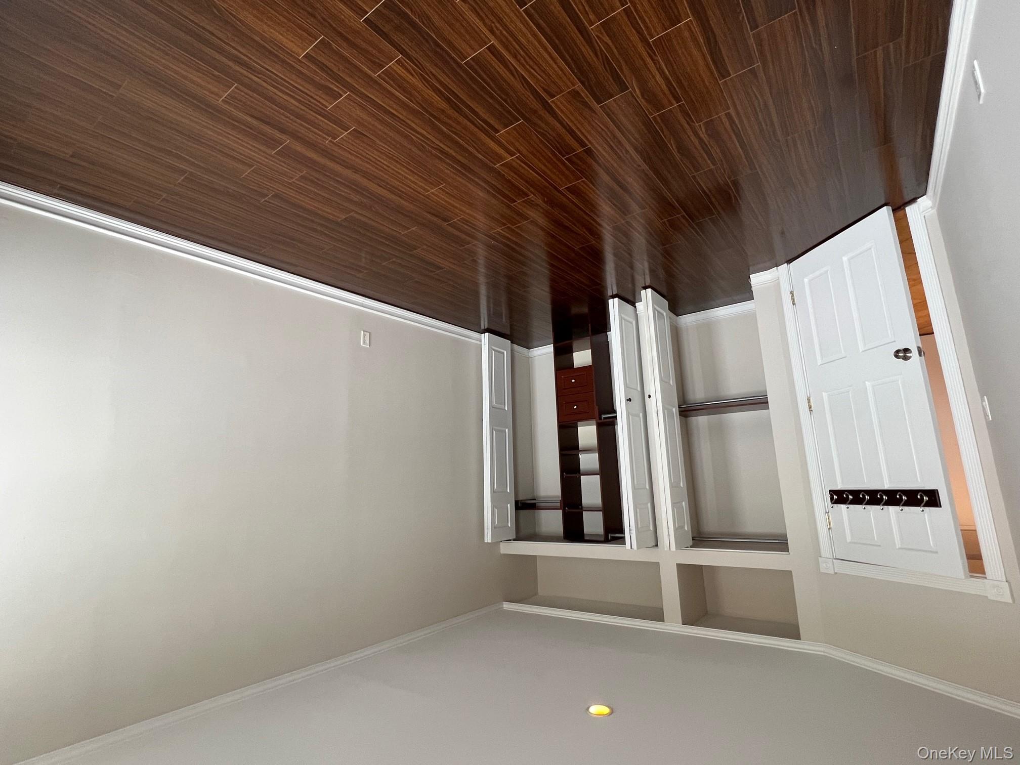 310 Riverside Boulevard, Unit 5H Long Beach, NY 11561 - Photo 11 of 13 an empty room with wooden floor and closet