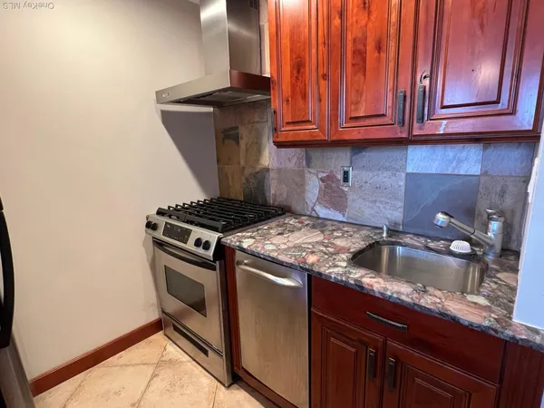 a kitchen with granite countertop a sink stove and cabinets