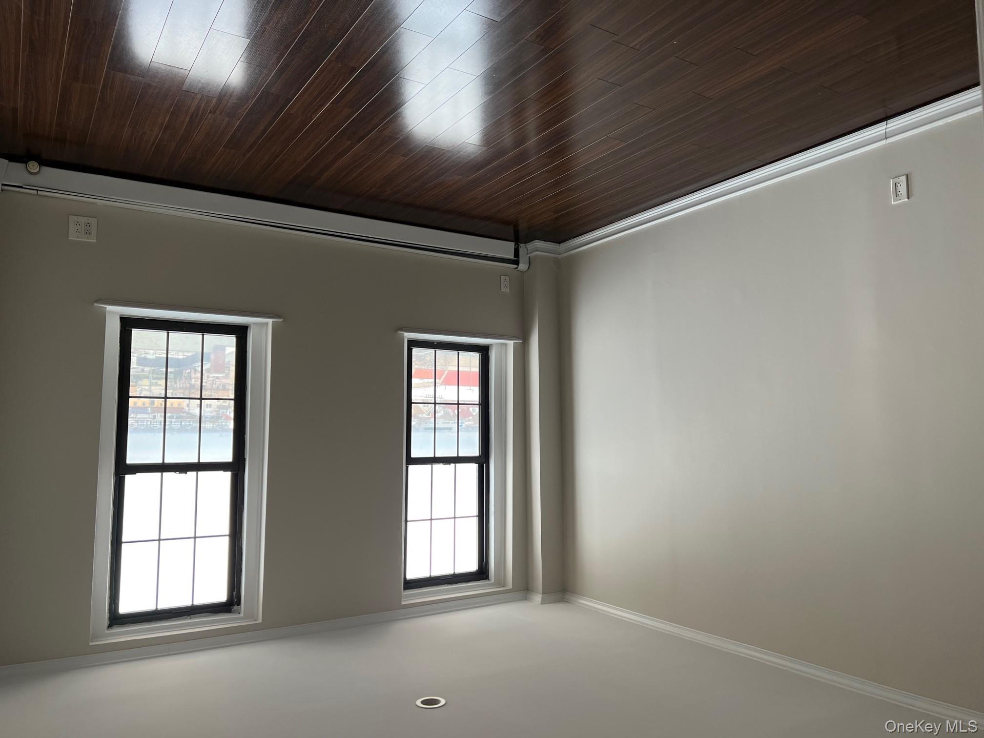 310 Riverside Boulevard, Unit 5H Long Beach, NY 11561 - Photo 10 of 13 an empty room with wooden floor and windows