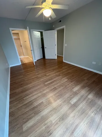 an empty room with wooden floor and entryway