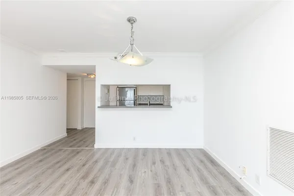 a view of empty room with wooden floor
