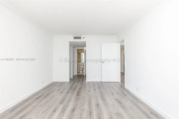 a view of an empty room with wooden floor