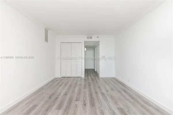 a view of an empty room with wooden floor