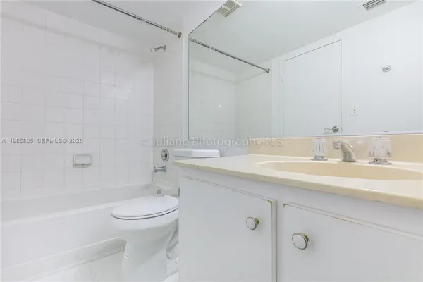 a bathroom with a granite countertop sink a toilet and shower