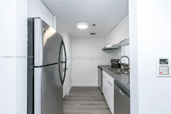 a kitchen with stainless steel appliances granite countertop a refrigerator and a stove