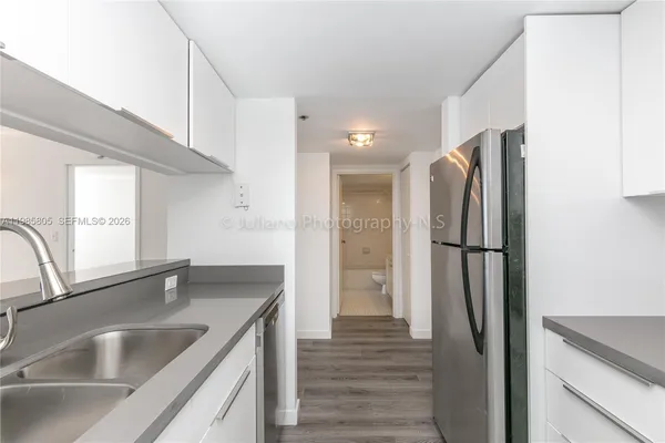 a kitchen with stainless steel appliances granite countertop a refrigerator and a sink