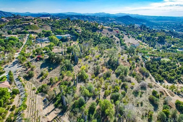 an aerial view of residential houses with outdoor space and trees