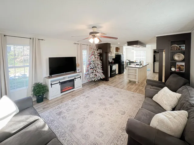 a living room with furniture a flat screen tv and a dining table