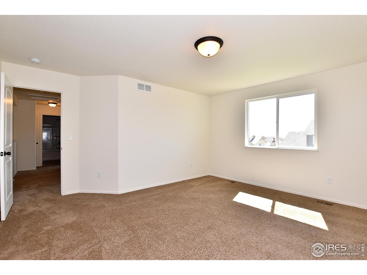 2310 Sublime Drive Windsor, CO 80550 - Photo 22 of 37 a view of an empty room with wooden floor and a window