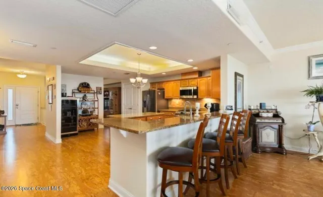 a dining room with furniture a chandelier and wooden floor