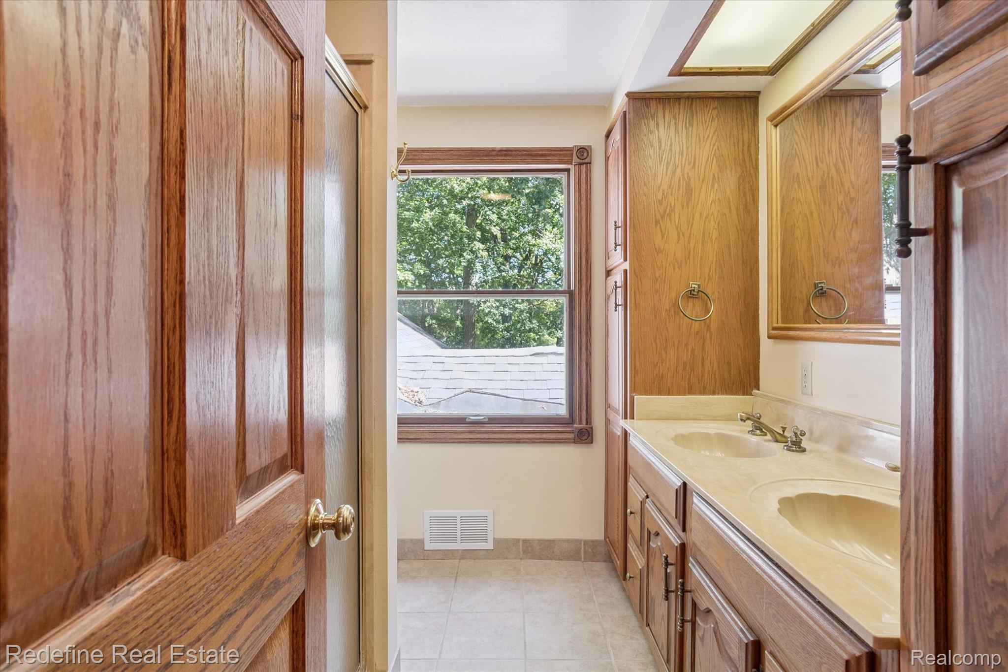3777 Dorr Road Brighton, MI 48116 - Photo 41 of 77 Bathroom with double vanity and light tile patterned floors