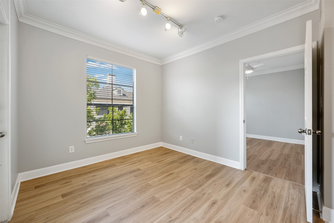 7701 Rialto Boulevard, Unit 1433 Austin, TX 78735 - Photo 18 of 31 an empty room with wooden floor and windows