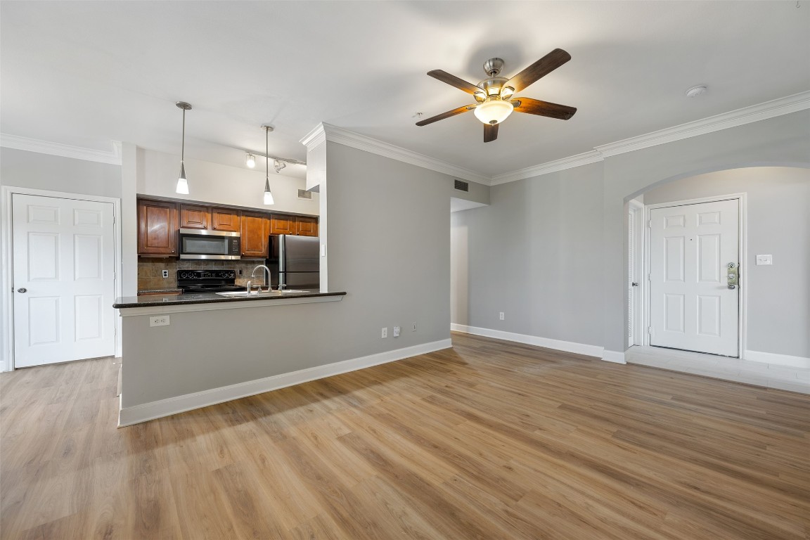 7701 Rialto Boulevard, Unit 1433 Austin, TX 78735 - Photo 5 of 31 a view of an empty room with wooden floor and a ceiling fan