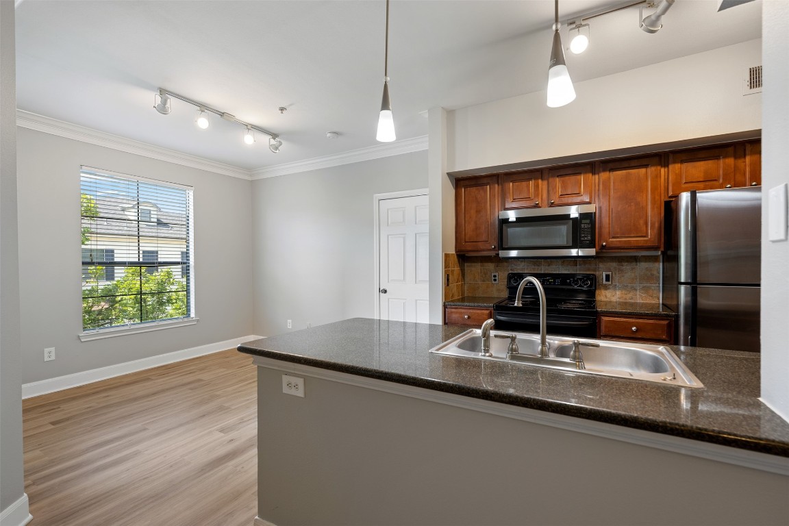 7701 Rialto Boulevard, Unit 1433 Austin, TX 78735 - Photo 6 of 31 a kitchen with kitchen island a sink appliances and cabinets
