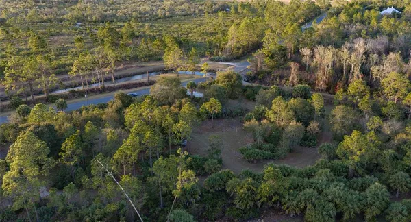 an aerial view of residential house with outdoor space and trees all around