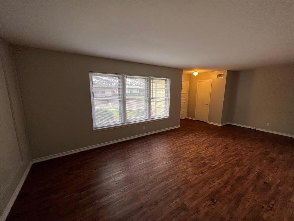 9302 Piper Lane Dallas, TX 75228 - Photo 4 of 13 an empty room with wooden floor and windows