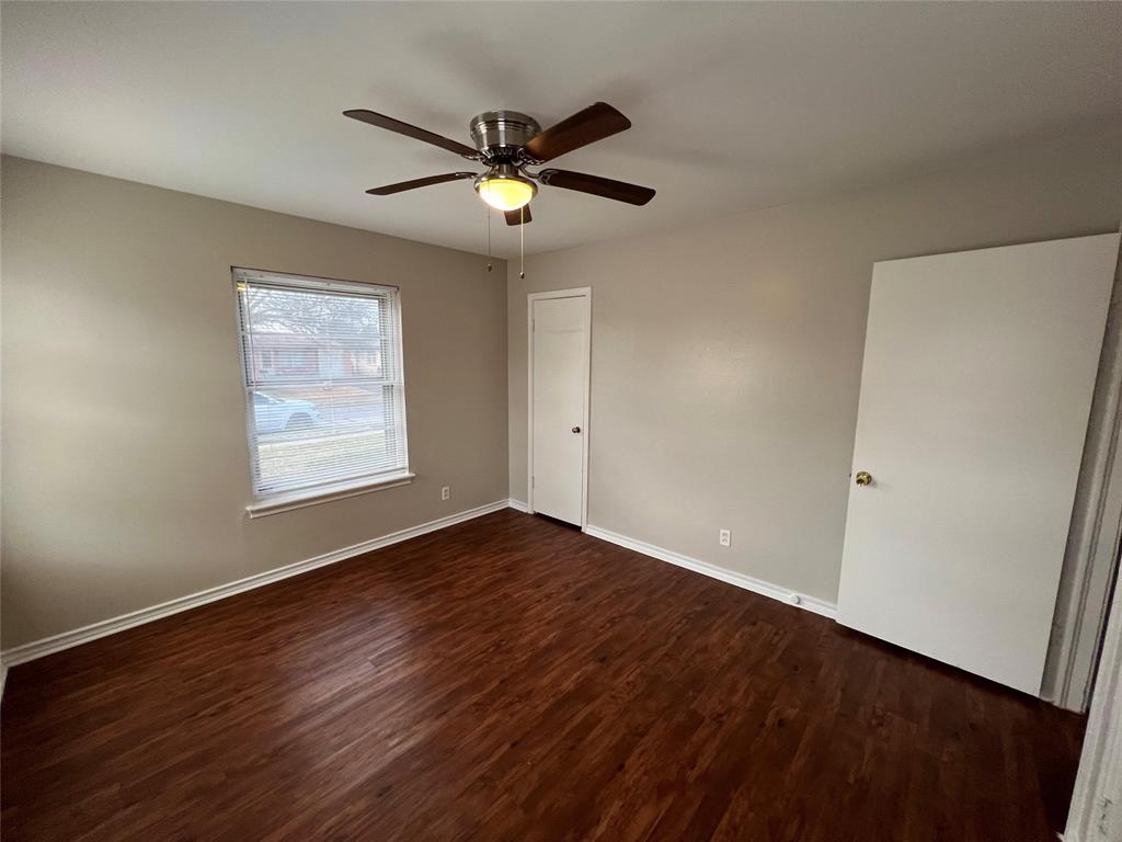 9302 Piper Lane Dallas, TX 75228 - Photo 5 of 13 an empty room with wooden floor fan and windows