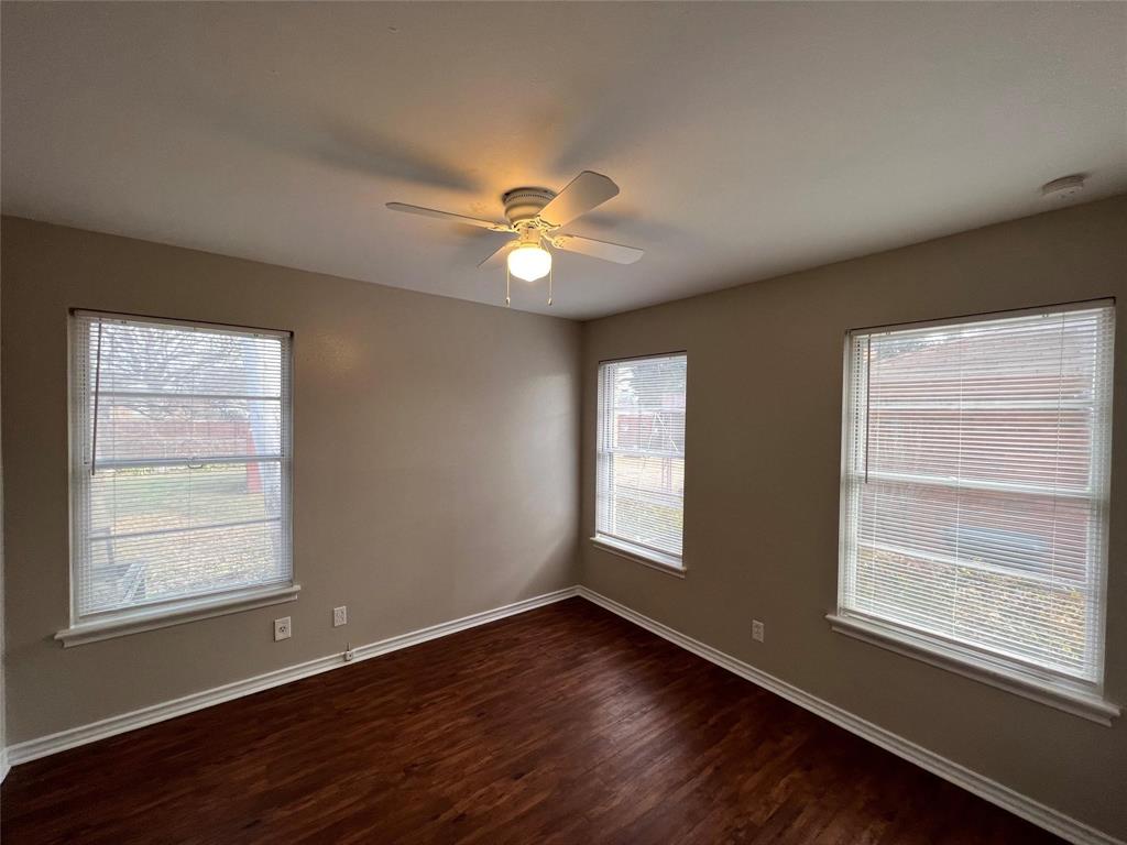 9302 Piper Lane Dallas, TX 75228 - Photo 6 of 13 a view of an empty room with a window and wooden floor