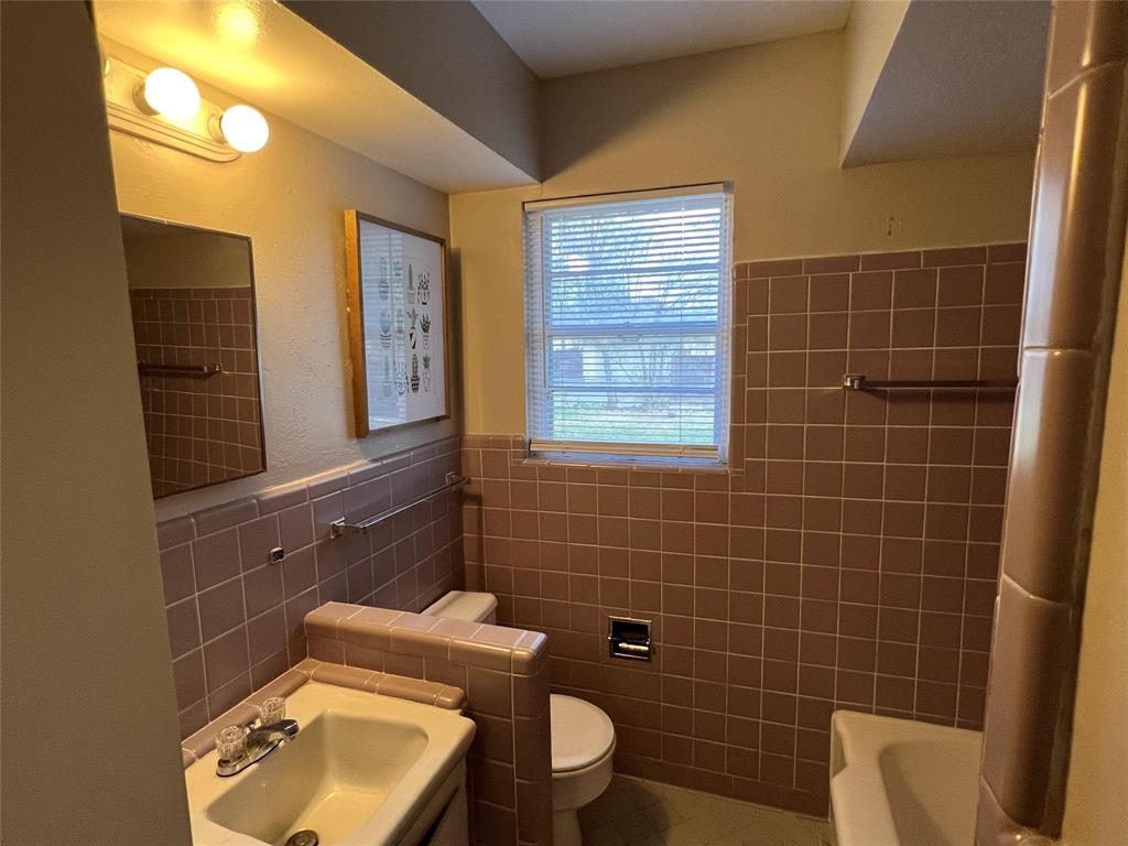 9302 Piper Lane Dallas, TX 75228 - Photo 8 of 13 a bathroom with a toilet a sink and mirror
