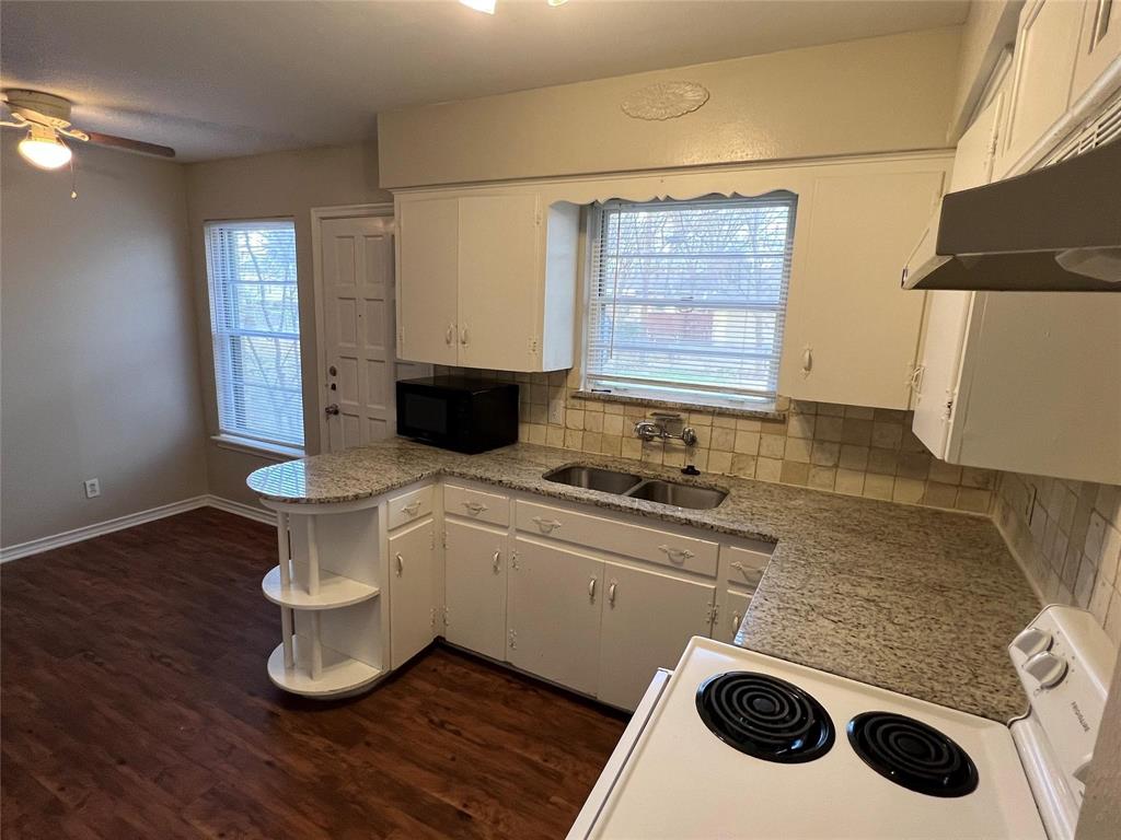 9302 Piper Lane Dallas, TX 75228 - Photo 10 of 13 a kitchen with a stove a sink and a microwave