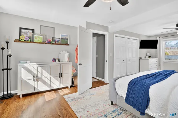 a bedroom with a bed and wooden floor