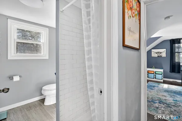 a bathroom with a toilet a sink and mirror