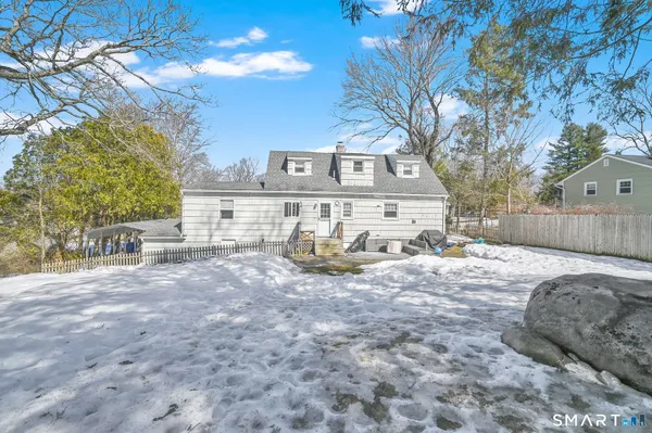 a front view of a house with a yard covered in snow
