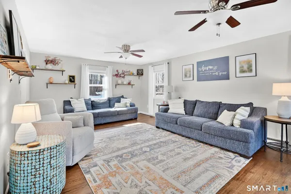 a living room with furniture and a wooden floor