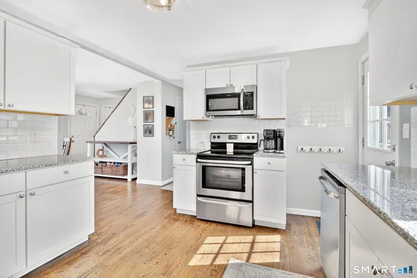 a kitchen with stainless steel appliances granite countertop a refrigerator a stove and a sink with granite countertops