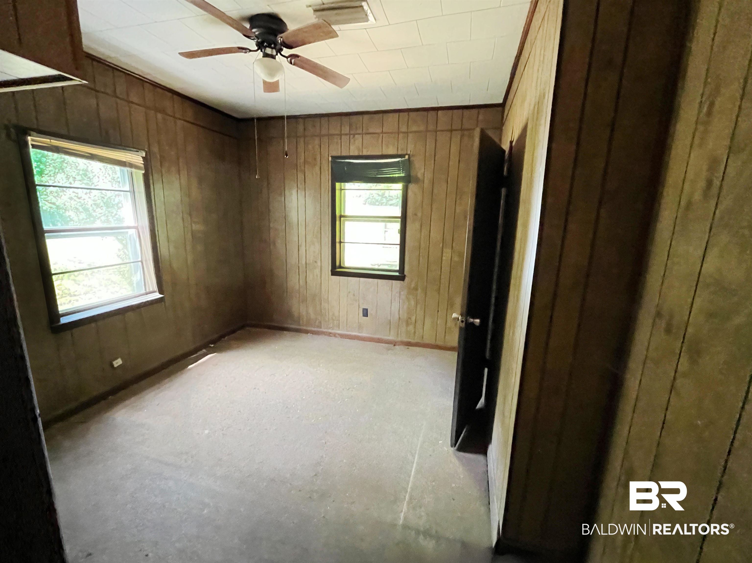 215 Adams Street Atmore, AL 36502 - Photo 6 of 7 Unfurnished bedroom featuring wooden walls and ceiling fan